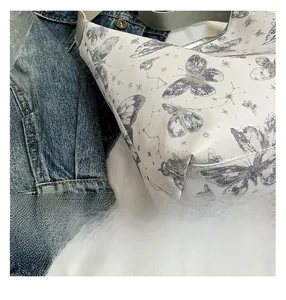 Dettaglio borsa shopper bianca con motivi a farfalla viola e stelle in pelle sintetica