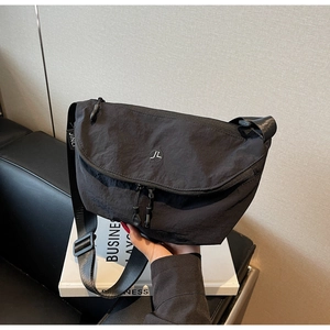 Dettaglio borsa a tracolla in nylon nero con logo rotondo e doppia zip di chiusura