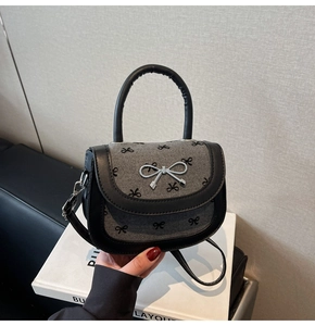 Close-up of bow print fabric and silver metal clasp on Korean saddle handbag
