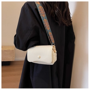 White pebbled leather crossbody bag with colorful ethnic style woven wide shoulder strap