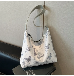 Dettaglio della borsa tote bianca con stampa artistica a farfalla grigia e stelle