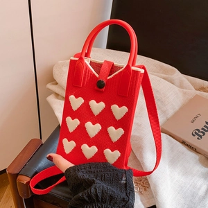 Red knitted mobile phone bag with white heart patterns and crossbody strap
