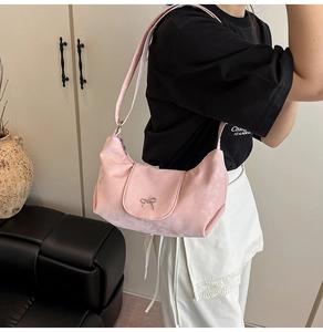 Détail du sac bandoulière rose avec boucle nœud argenté et texture douce et lisse