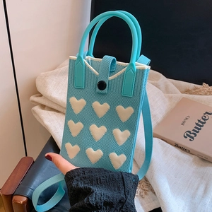 Light blue knitted phone bag with white hearts, dual handles and crossbody strap