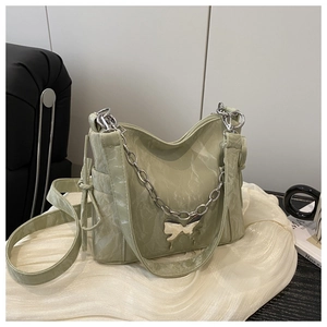 Détail du sac plissé vert avec chaîne argentée et pendentif papillon métallique élégant