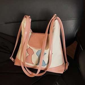 Sac fourre-tout minimaliste beige et rose avec silhouettes de chats sur un fauteuil en cuir