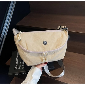 Dettaglio borsa a tracolla beige a mezzaluna con doppia cerniera e tracolla regolabile