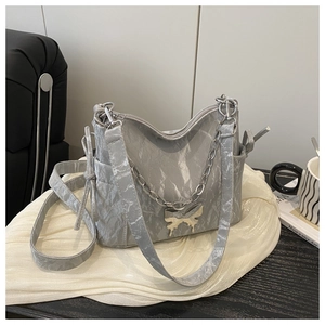 Détail du sac bandoulière marbré avec pendentif papillon et chaîne en métal argenté