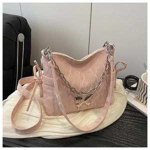 Détail du sac à bandoulière rose avec texture plissée et ornement papillon argenté