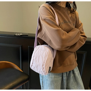 Gros plan sur le mini sac bandoulière en nylon lilas avec bandoulière large tissée