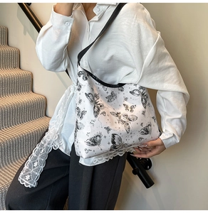 Vista dettagliata della grande borsa a tracolla con stampe di farfalle nere da donna