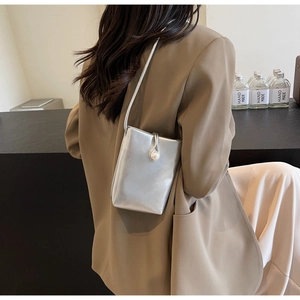 Detail of silver rectangular crossbody bag with pearl clasp and metallic finish