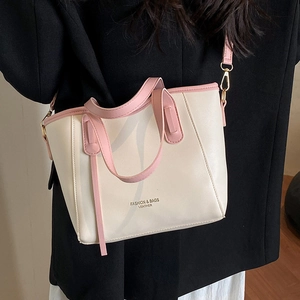 Franse stijl emmer tas met roze bies getoond in een strakke studio lifestyle foto