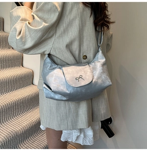 Sac à bandoulière argenté avec nœud porté avec un blazer beige pour un look urbain