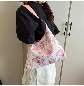 Dettaglio della borsa tote bianca con stampe di farfalle rosa e ampia tracolla morbida