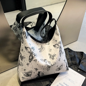Borsa tote bianca moderna con stampe di farfalle nere e manici in pelle su sfondo chic
