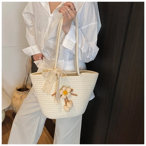 Detail of cream woven tote bag featuring decorative 3D flowers and delicate lace bow accent