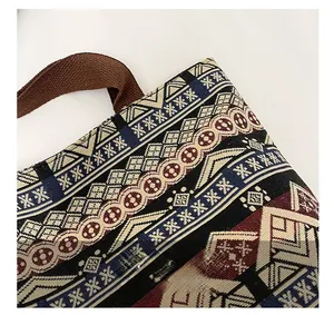 Detailed close-up of bohemian woven tote bag with ethnic patterns and brown strap
