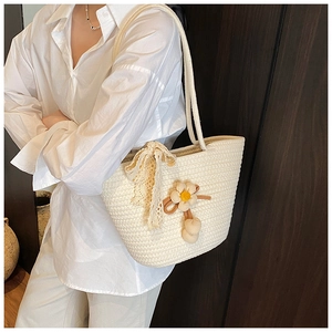Detail of hand-woven off-white bucket bag with lace bow and yellow flower accessory