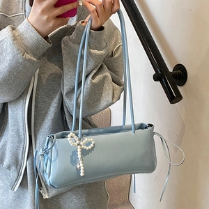 Light blue glossy underarm bag with pearl bow decoration and ribbon drawstring details