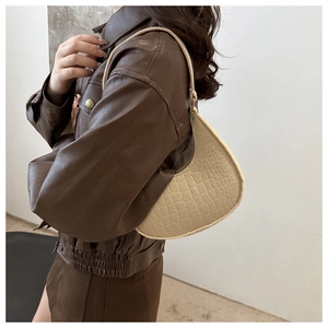 Détail du sac sous le bras en beige chaud avec texture crocodile et sangle en cuir fin