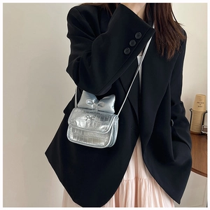 Detail of silver crocodile pattern mini crossbody bag with a large 3D bow and metal logo