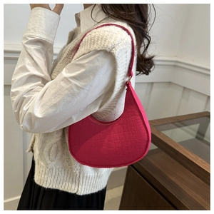 Détail du sac hobo fuchsia avec motif crocodile porté sur l'épaule de la femme