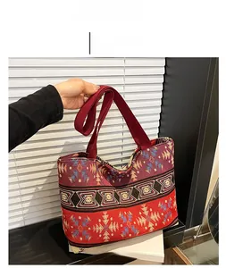 Close-up of geometric ethnic pattern tote bag with vibrant red woven shoulder straps