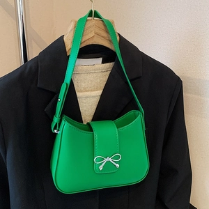 Minimalist bright green faux leather baguette bag with a silver metal bow accent