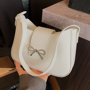 Minimalist white faux leather crescent shoulder bag with a silver bow buckle detail