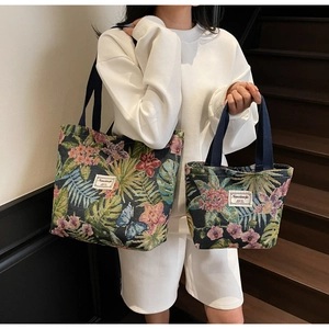 Detail of two jacquard canvas tote bags in blue floral pattern showing size comparison