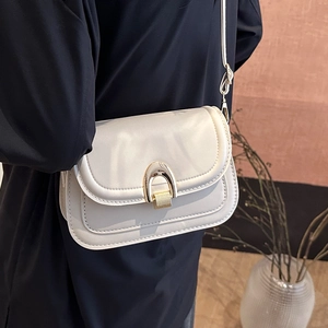 Elegant off-white vintage crossbody bag with gold horseshoe buckle and adjustable strap
