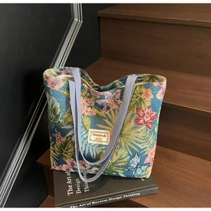 Detail of jacquard woven tote bag featuring floral patterns and dual textile handles