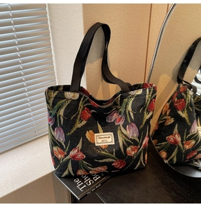 Close-up of vintage knitted tote bag featuring colorful tulip patterns and brand label