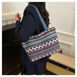 Detailed view of canvas tote with colorful geometric patterns and blue shoulder strap