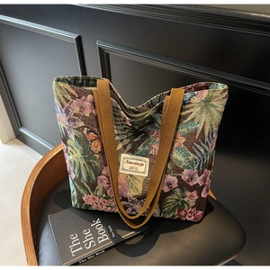 Macro view of vintage floral tapestry fabric and textured embroidery on tote bag