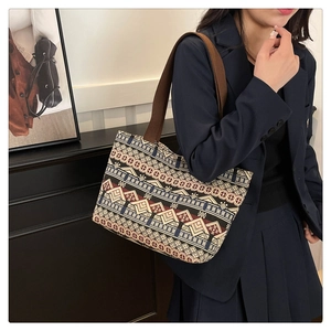 Close-up of ethnic geometric pattern jacquard tote bag with wide brown canvas shoulder strap