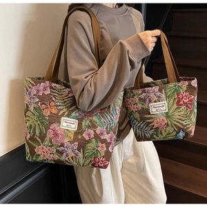 Detail of vintage floral jacquard tote bag with textured flower pattern and woven handles