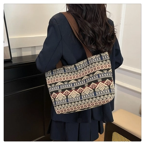Ethnic tote bag with geometric patterns shown on a model in a stylish interior setting
