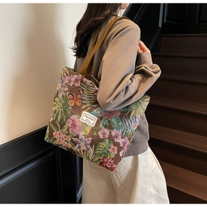 Detail of floral tapestry tote bag with butterfly patterns and durable brown handle
