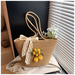 Detailed close-up of woven tote bag with lace bow and yellow crochet flower charms