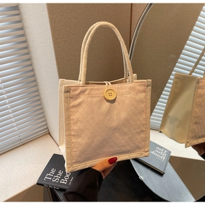 Dettaglio della borsa tote in lino con trama a squame e manici in corda rustica