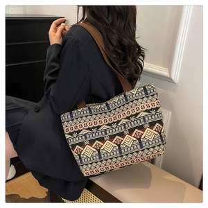 Ethnic style tote bag with geometric patterns and brown wide shoulder strap on model