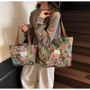 Detail of two jacquard canvas tote bags with tropical floral patterns and brown straps