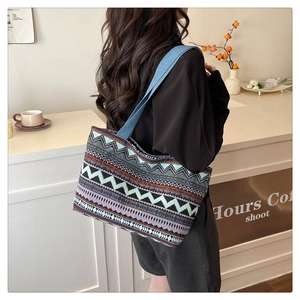 Close-up of geometric pattern canvas tote bag on a model in a cozy cafe setting