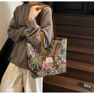 Detailed shot of vintage floral canvas tote bag featuring premium brocade texture and handles
