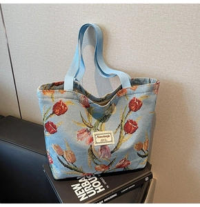 Detailed view of tulip jacquard knit fabric and Nanxiaojie logo on a large tote bag