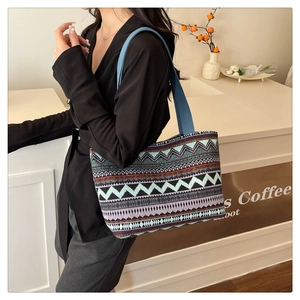 Ethnic geometric pattern tote bag shown over shoulder in a modern cafe setting