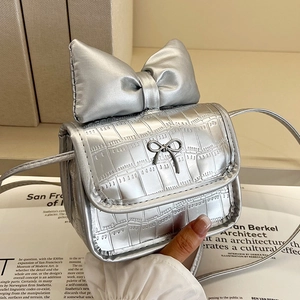Chic silver mini crossbody bag with large bow detail and textured crocodile embossing