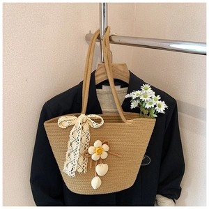 Detailed view of handmade woven tote bag with 3D floral charms and lace bow decoration